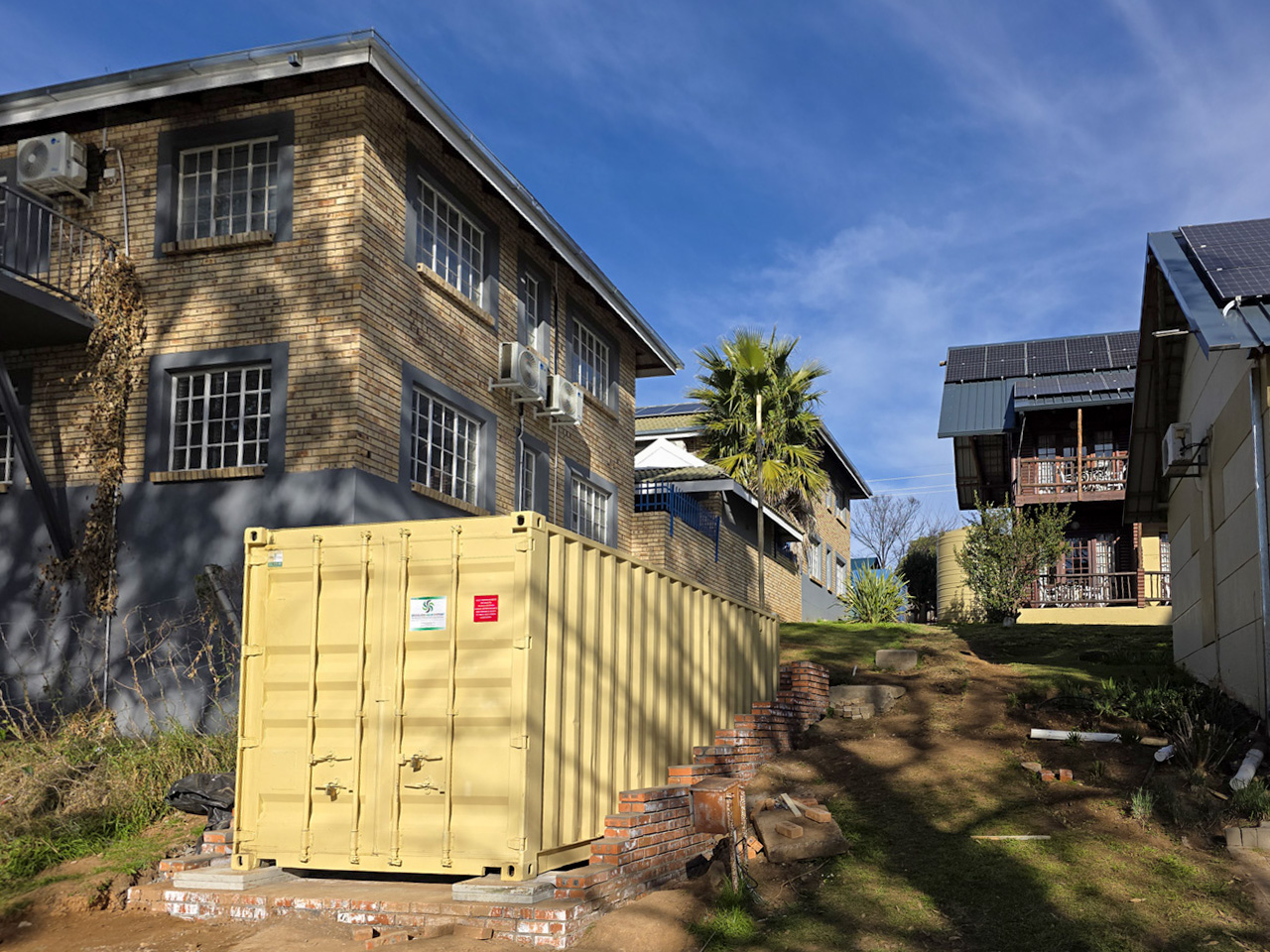 Containerised solar installation at Riverside Lodge with restricted access and surrounding infrastructure