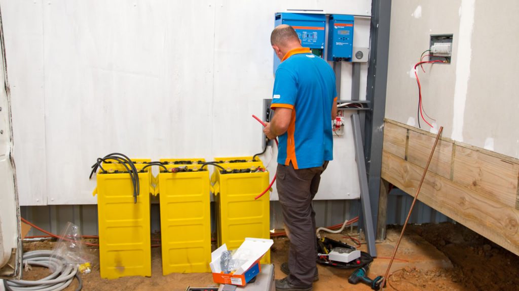 technician working on older lead-acid battery cells