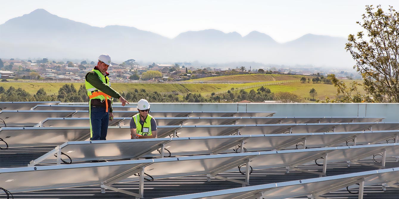 Inspecting the solar panels of a 200 kVA grid-tied solar power system in George, the Western Cape. Specialized Solar Systems Engineers